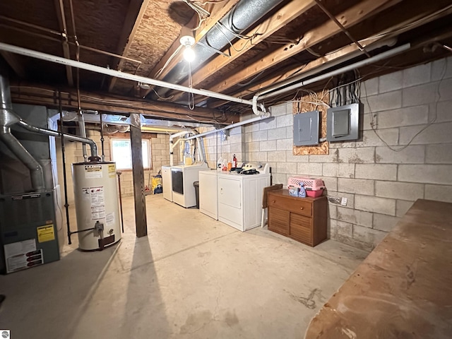 below grade area featuring electric panel, heating unit, washing machine and clothes dryer, and gas water heater