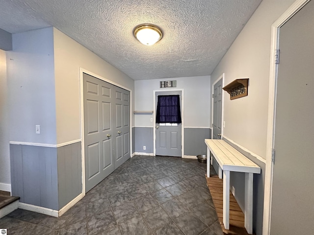 entrance foyer featuring a textured ceiling and stairway
