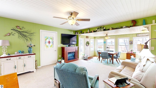 17429 Summit Ct, Barryton, MI 49305 - living area featuring light carpet, ceiling fan, a glass covered fireplace, and wood ceiling