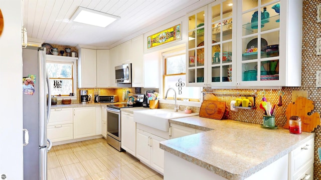 17429 Summit Ct, Barryton, MI 49305 - kitchen featuring stainless steel appliances, a sink, tasteful backsplash, white cabinets, and light tile patterned floors