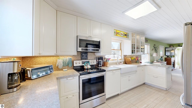 17429 Summit Ct, Barryton, MI 49305 - kitchen with stainless steel appliances, a sink, light countertops, backsplash, and white cabinetry