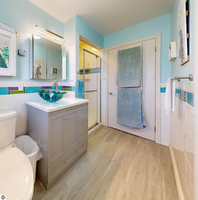 17429 Summit Ct, Barryton, MI 49305 - bathroom with tile walls, wood finished floors, a shower stall, toilet, and vanity