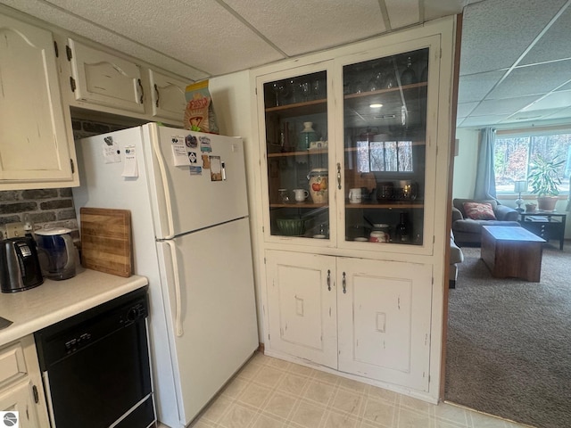 kitchen with light countertops, dishwasher, light floors, a drop ceiling, and freestanding refrigerator