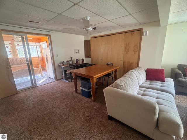 carpeted living room featuring a drop ceiling, a ceiling fan, and visible vents