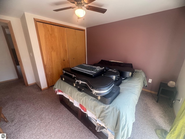 carpeted bedroom with a closet, baseboards, and a ceiling fan