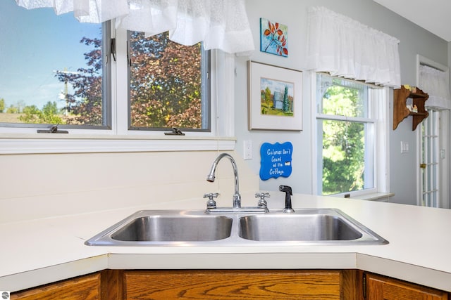 3275 S Sunrise Ln, Lake Leelanau, MI 49653 - kitchen with light countertops, a sink, and brown cabinets