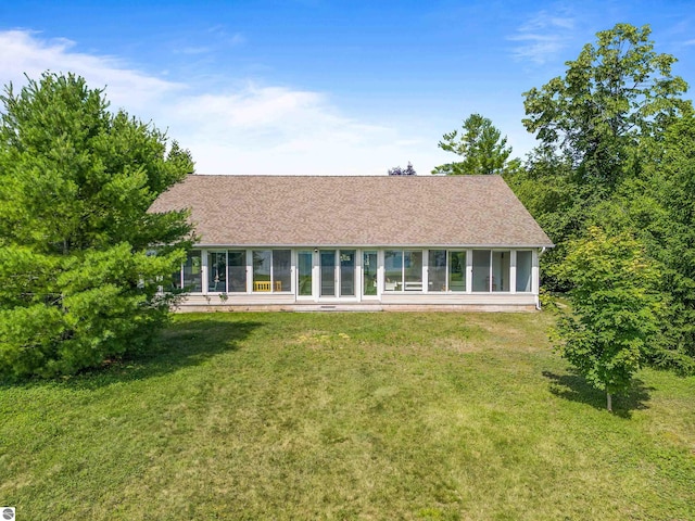 3275 S Sunrise Ln, Lake Leelanau, MI 49653 - rear view of property with a sunroom, roof with shingles, and a yard