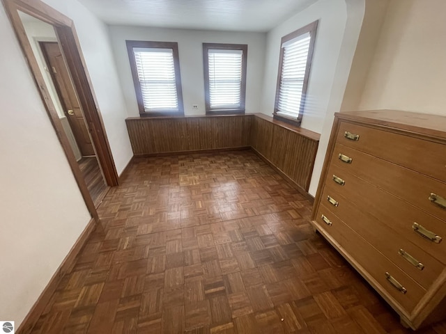 interior space with a wainscoted wall and wooden walls