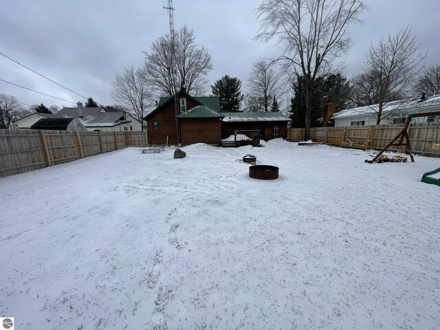 yard covered in snow with a fenced backyard