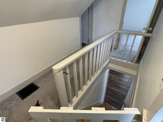 staircase with baseboards, visible vents, and carpet flooring
