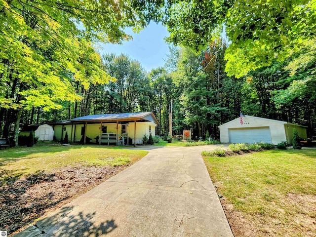 8468 Shorewood Ct, Mancelona, MI 49659 - view of front facade featuring a porch, a detached garage, an outbuilding, and a front lawn