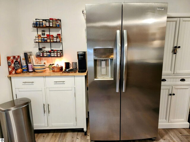 8468 Shorewood Ct, Mancelona, MI 49659 - kitchen featuring white cabinets, light countertops, stainless steel fridge with ice dispenser, and light wood-style floors