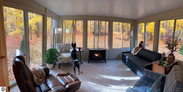 8468 Shorewood Ct, Mancelona, MI 49659 - sunroom / solarium featuring lofted ceiling, a decorative wall, a wood stove, and carpet