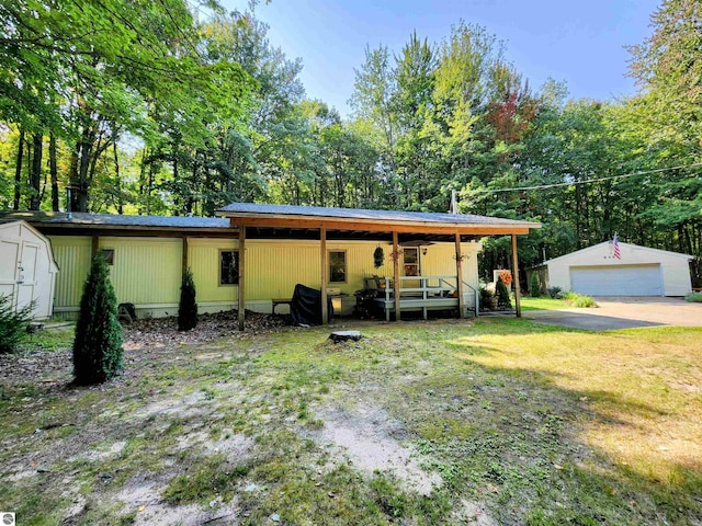 8468 Shorewood Ct, Mancelona, MI 49659 - rear view of property with a lawn, an outbuilding, and a detached garage
