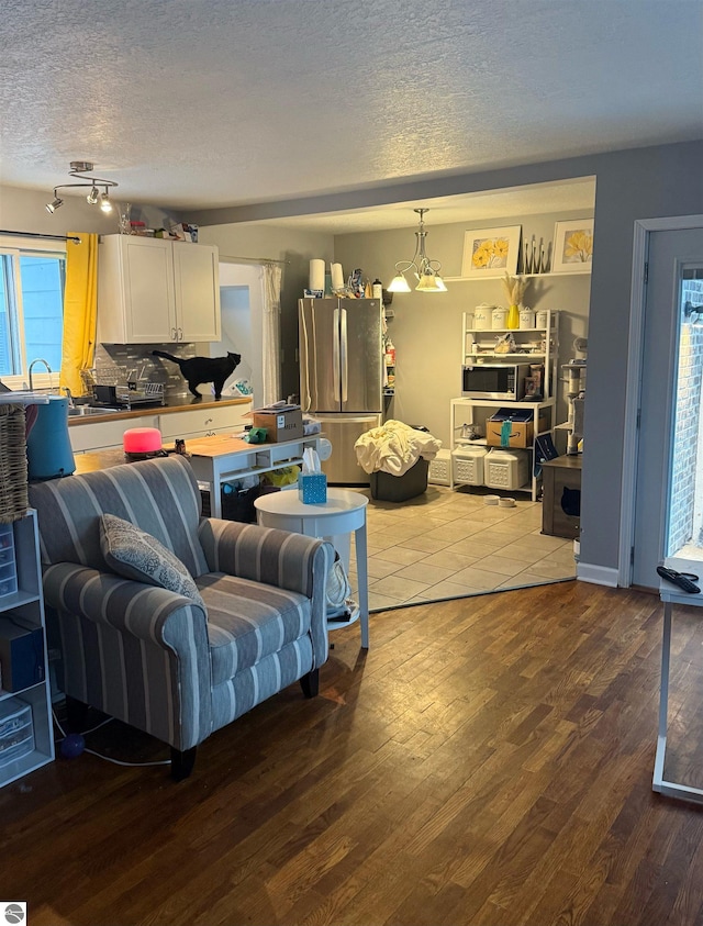 6133 W Airline Rd, Weidman, MI 48893 - living room with a textured ceiling, wood finished floors, and plenty of natural light
