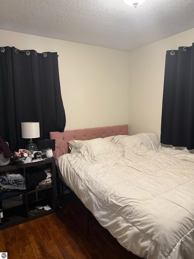 6133 W Airline Rd, Weidman, MI 48893 - bedroom featuring a textured ceiling and wood finished floors