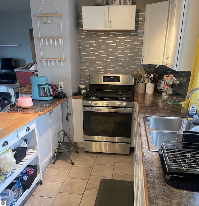 6133 W Airline Rd, Weidman, MI 48893 - kitchen with white cabinetry, a sink, dark countertops, and stainless steel gas range