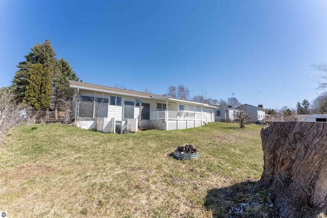 back of property with a yard and fence
