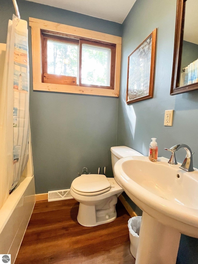 160 White Birch Ln, Cadillac, MI 49601 - bathroom featuring visible vents, baseboards, wood finished floors, toilet, and shower / tub combo with curtain
