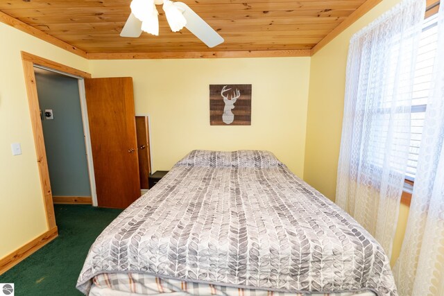 9701 S Lake Station Ave, Lake, MI 48632 - bedroom with multiple windows, dark carpet, wood ceiling, and baseboards