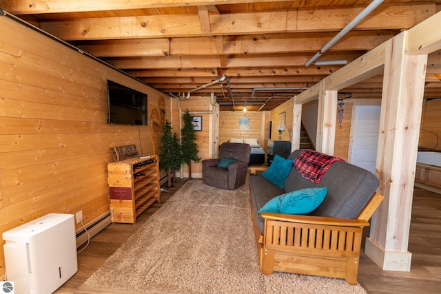 9701 S Lake Station Ave, Lake, MI 48632 - basement featuring a baseboard radiator, wood finished floors, wood walls, and stairway
