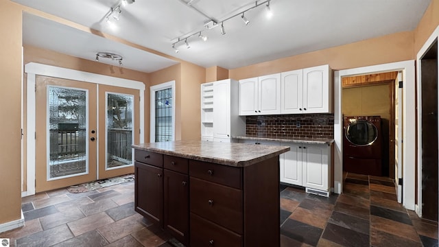 kitchen featuring white cabinetry, stone tile floors, french doors, backsplash, and a kitchen island