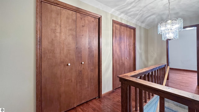 hall featuring a notable chandelier, an upstairs landing, lofted ceiling, baseboards, and dark wood-style flooring