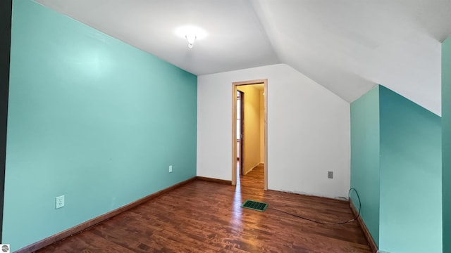 additional living space with baseboards, visible vents, wood finished floors, and lofted ceiling