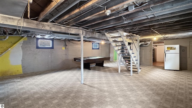 basement with freestanding refrigerator, plenty of natural light, pool table, and stairs