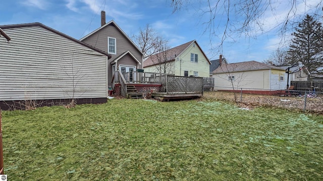 back of property featuring fence, a wooden deck, and a yard
