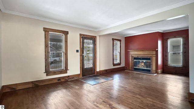 entryway with crown molding, a fireplace, wood finished floors, baseboards, and visible vents