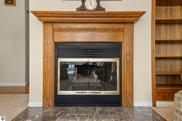 interior details with baseboards and a glass covered fireplace