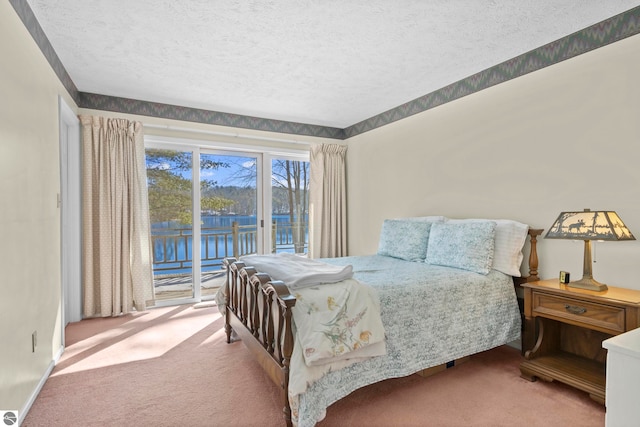 bedroom featuring access to exterior, carpet, and a textured ceiling