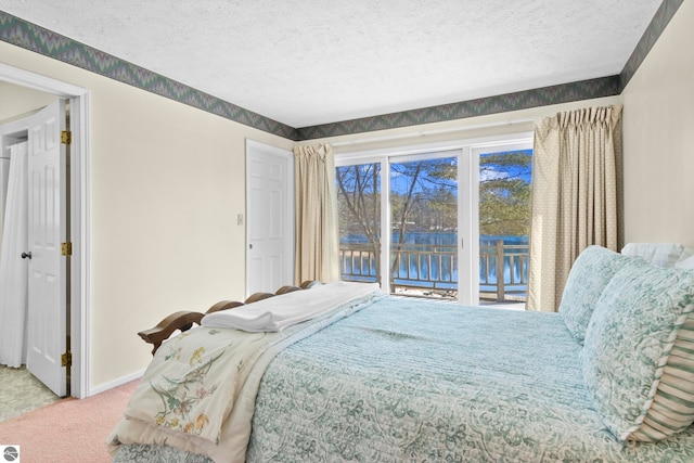 bedroom featuring baseboards, carpet floors, a textured ceiling, and access to outside
