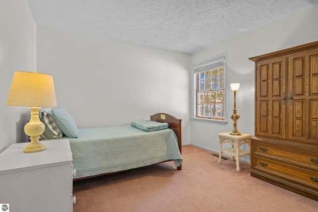bedroom with baseboards, a textured ceiling, and light carpet