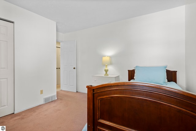 bedroom with baseboards, light colored carpet, and visible vents