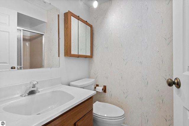full bath featuring toilet, a stall shower, and vanity