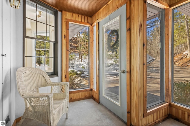 unfurnished sunroom featuring wood walls