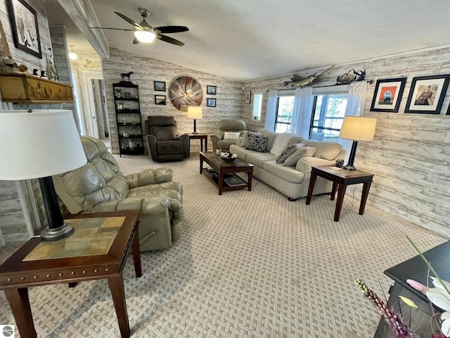 living area featuring light carpet, lofted ceiling, ceiling fan, and a textured ceiling