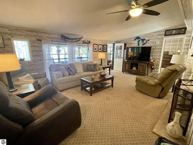 living area with a ceiling fan, light carpet, vaulted ceiling, and a textured ceiling