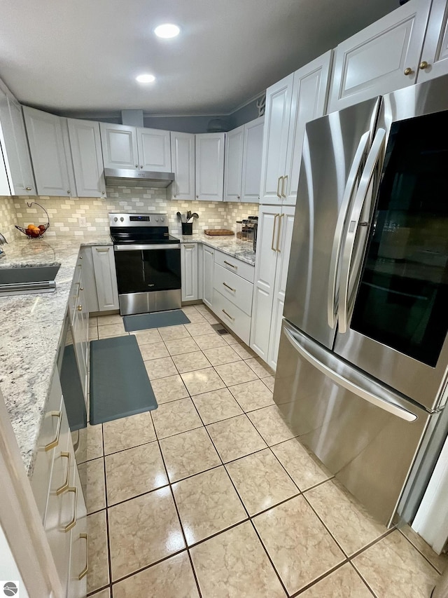 kitchen featuring stainless steel appliances, backsplash, under cabinet range hood, a sink, and light stone counters