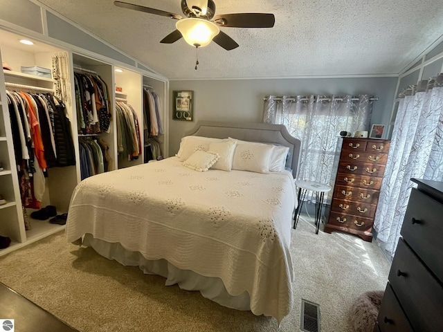 bedroom featuring a textured ceiling, ornamental molding, ceiling fan, and a closet