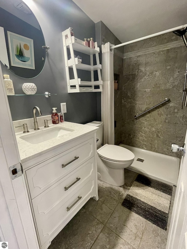 bathroom with a shower stall, toilet, and vanity