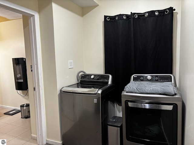 131 E State, Mancelona, MI 49659 - washroom with tile patterned floors, washing machine and dryer, baseboards, and laundry area