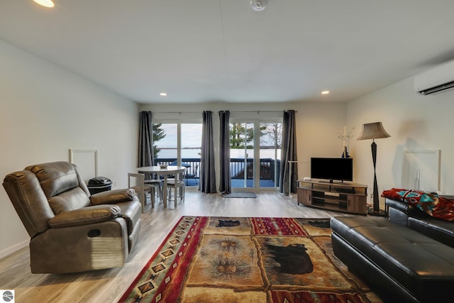 living room with a wall mounted AC, recessed lighting, and wood finished floors