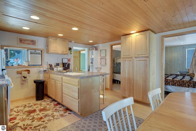 kitchen featuring a sink, light brown cabinetry, recessed lighting, and a peninsula