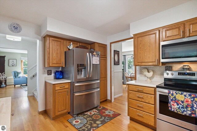 kitchen featuring light countertops, a wealth of natural light, tasteful backsplash, and appliances with stainless steel finishes