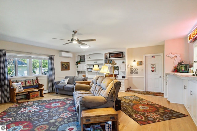living area featuring a wall mounted AC, light wood-style flooring, and ceiling fan