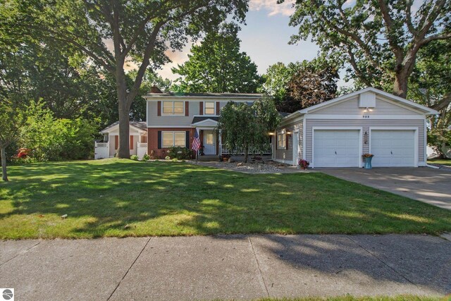 view of front of house with driveway, a front yard, and a garage