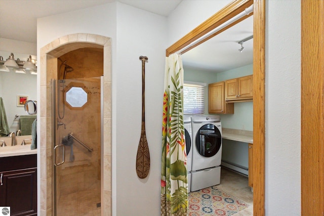 laundry area with independent washer and dryer, light tile patterned floors, a sink, cabinet space, and baseboard heating